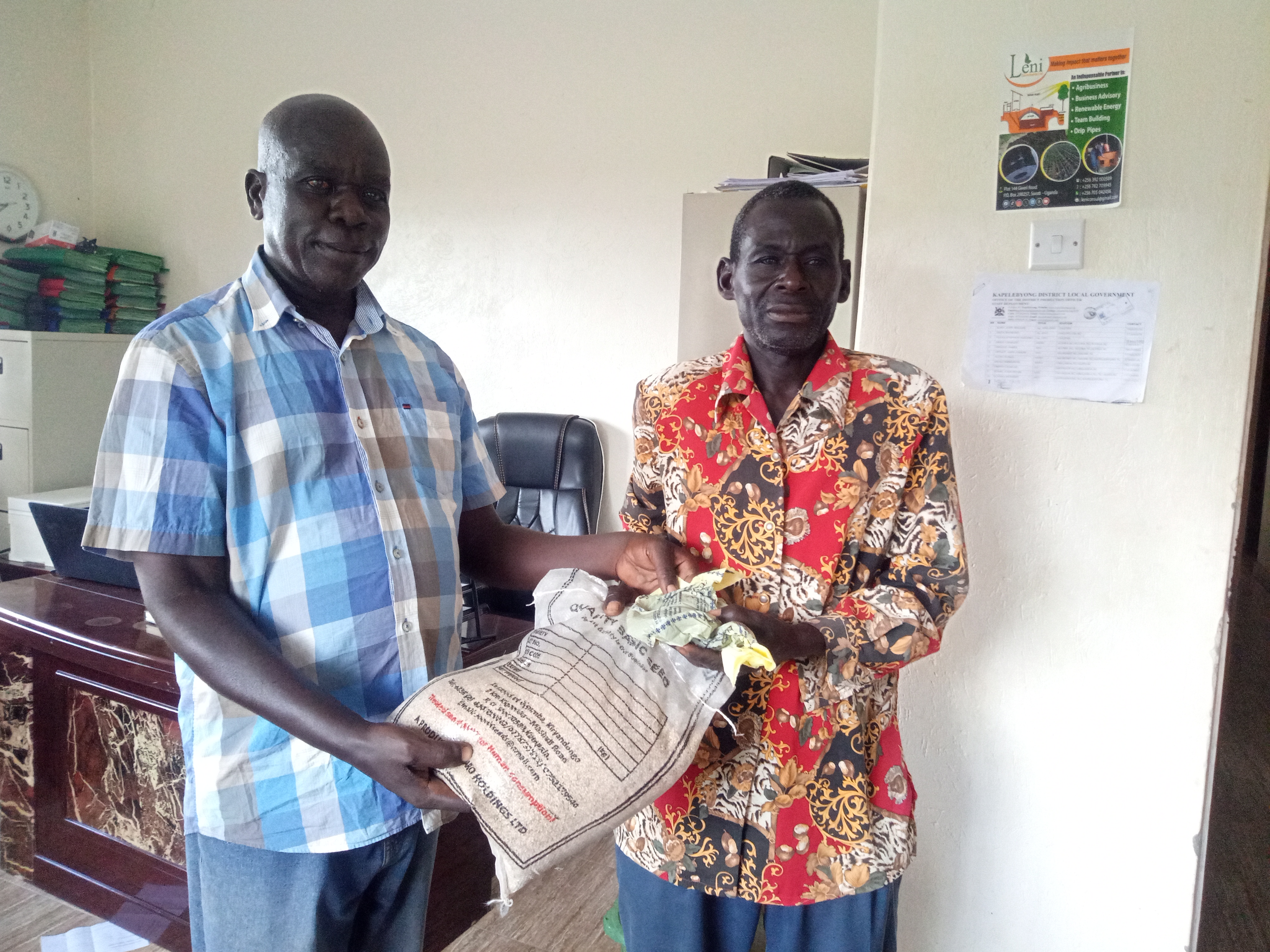 One local farmer receiving seeds from Mr. Eceru Peter, the Agric Extension Officer of Kapelebyong in the Production office on Thursday.jpg 